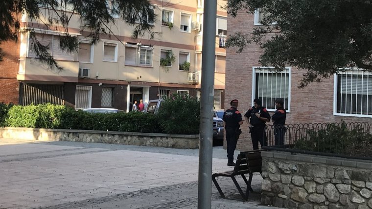 Tres agents dels Mossos d'Esquadra esperant als afores de l'edifici on vivia el presumpte terrorista