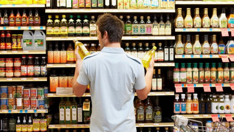 Un consumidor mirando las etiquetas de los productos del supermercado.