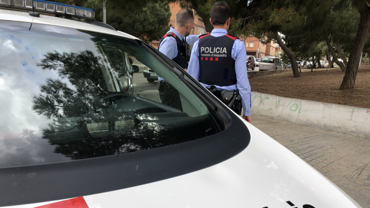 Dos agents dels Mossos amb un vehicle policial