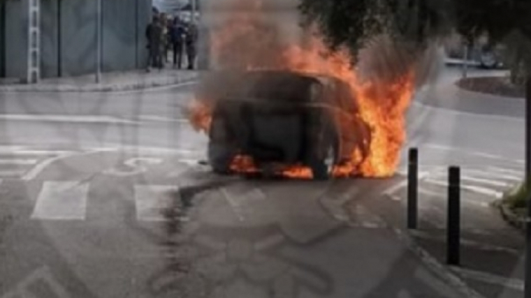 El cotxe cremant al mig del carrer.