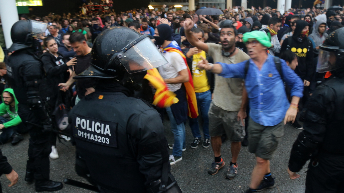 Un agent de la policia davant d'un grup de manifestants a l'aeroport del Prat convocats per Tsunami Democràtic, el 14 d'octubre del 2019
