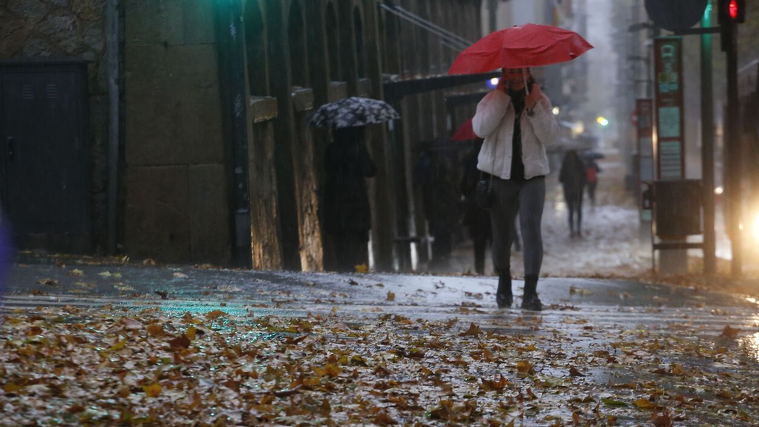 Imatge del pas d'una borrasca amb pluja, vent i gent amb el paraigÃ¼es