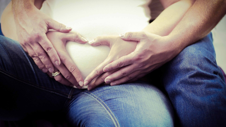 Imagen de archivo de unos padres con sus manos en la barriga de la mujer embarazada