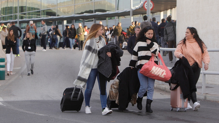 Passatgeres amb les maletes en un aeroport