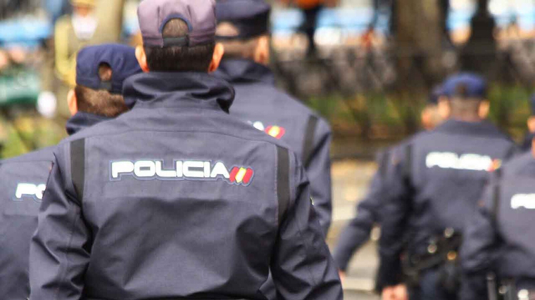 Varios agentes de la PolicÃ­a Nacional en uniforme, de espaldas