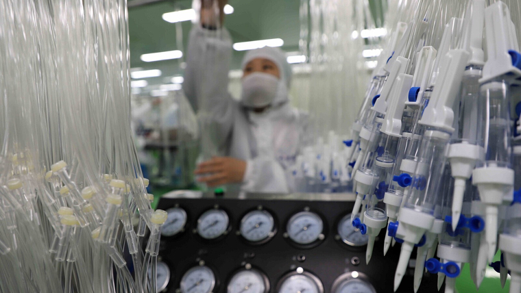 Treballadors en una lÃ­nia de producciÃ³ de material mÃ¨dic per afrontar el coronavirus el febrer de 2020