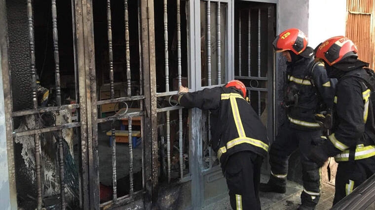Bombers en l'extinció d'un incendi en la planta baixa d'una casa en Vila-real