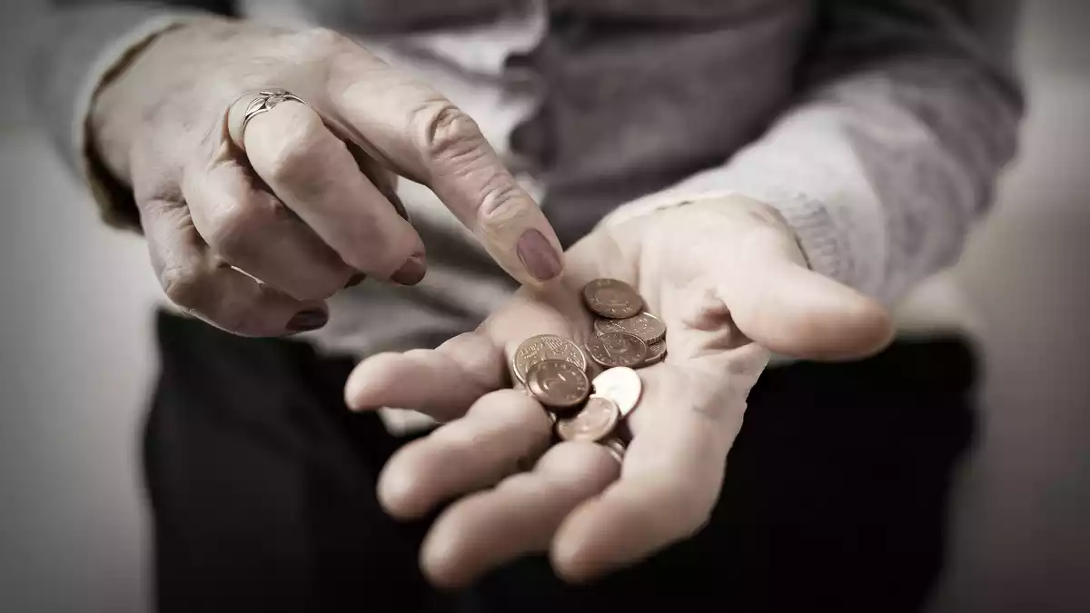 Imagen de una mujer contando las monedas que tiene en la mano Imagen de una mujer contando las monedas que tiene en la mano