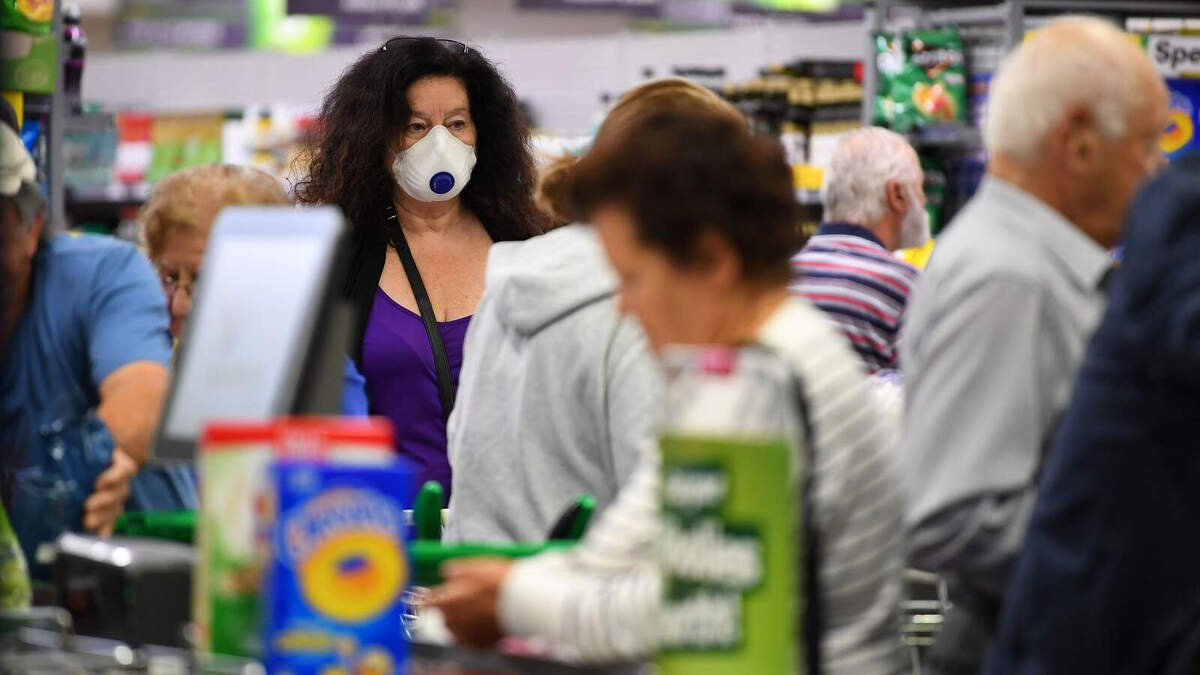 Una dona amb mascareta comprant en un supermercat