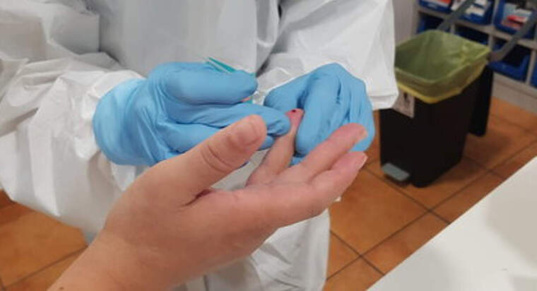 Un profesional sanitari extreu una mostra de sang per una prova per detectar coronavirus a una residència de la Pobla de Segur, el 13 d'abril de 2020