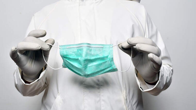 Imagen de archivo de una persona sosteniendo una mascarilla