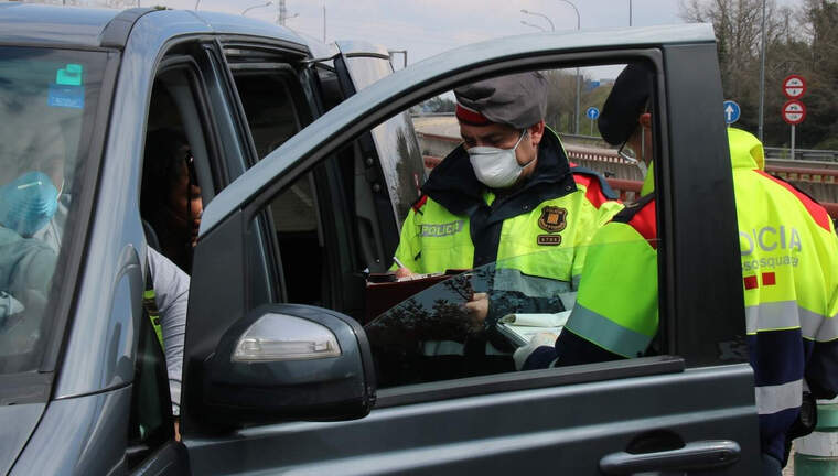Instant en què els Mossos imposen la sanció als ocupants de la furgoneta aquest dissabte 21 de març de 2020 a Maçanet de la Selva.