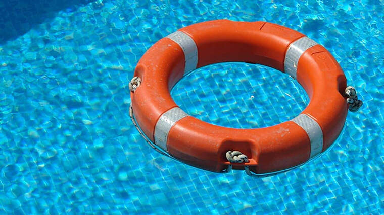 Imagen de un salvavidas naranja en una piscina