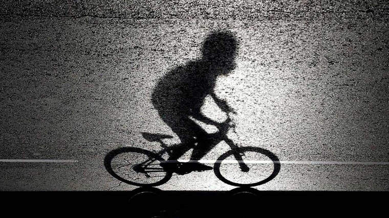 Silueta d'un ciclista circulant per una carretera