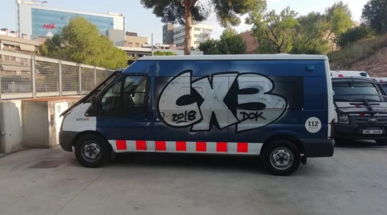 La furgoneta, ja al matí, pintada amb CX3, la marca d'una banda llatina.