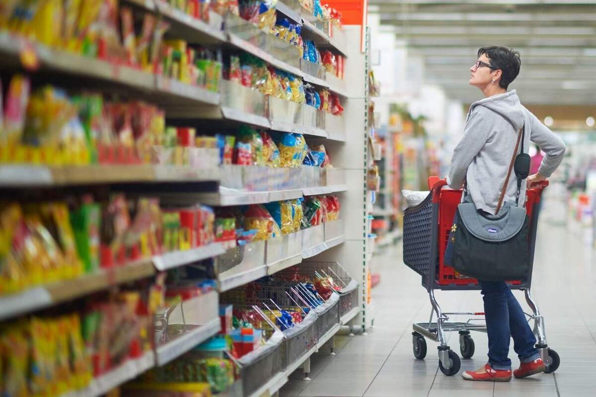 Imatge d'una dona mirant les prestatgeries d'un supermercat.