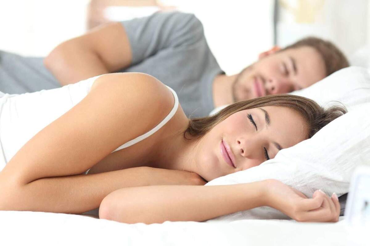 Imatge d'una parella dormint junts a un llit