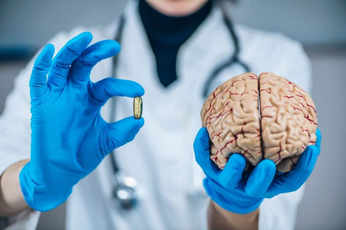Imatge d'un metge ensenyant una pastilla i un cervell