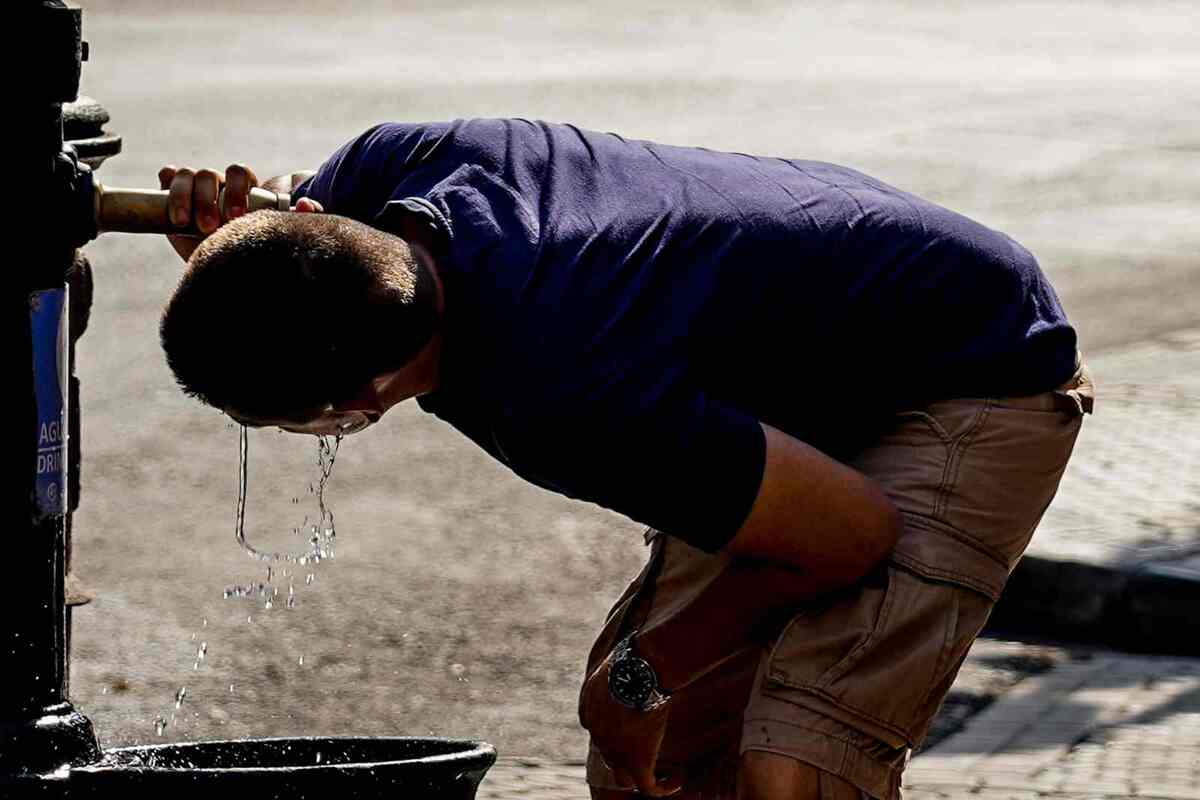 Imatge d'una persona hidratant-se en plena onada de calor del 2022 a Sevilla.