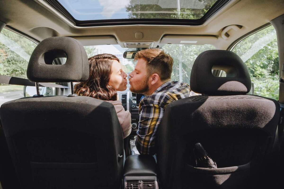 Parella a punt de fer-se un petó en el cotxe