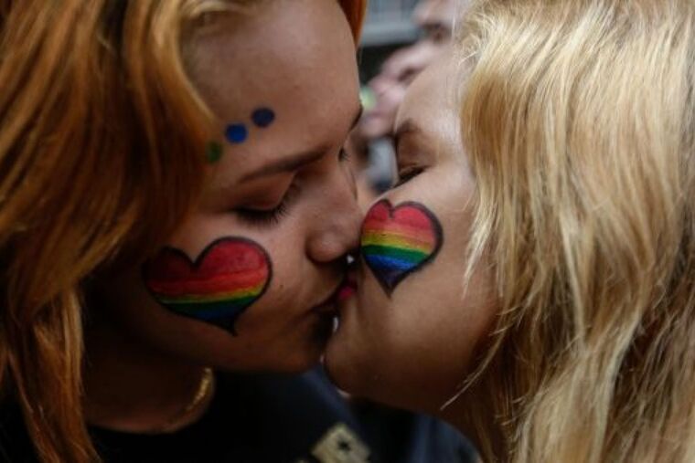 Foto de dues dones fent-se un petó el dia de l'Orgull LGTBIQ+.