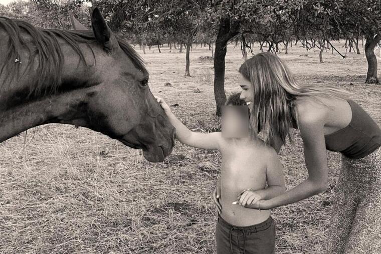 Imatge d'Ana Soria amb un nen al camp i acariciant un cavall