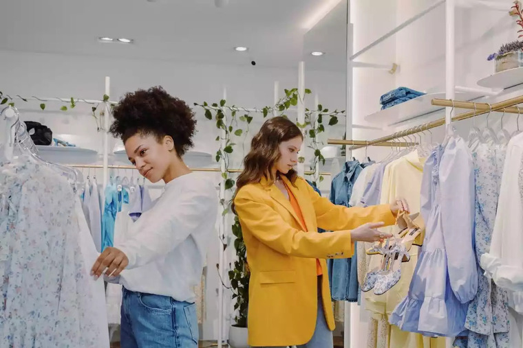 Foto de dues dones mirant roba en una botiga