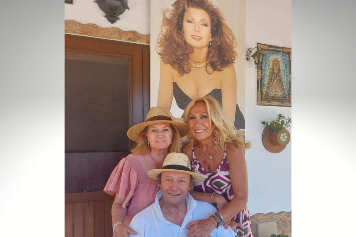 Foto de Rosa Benito, Gloria i Amador Mohedano posant amb una imatge de Rocío Jurado de fons.
