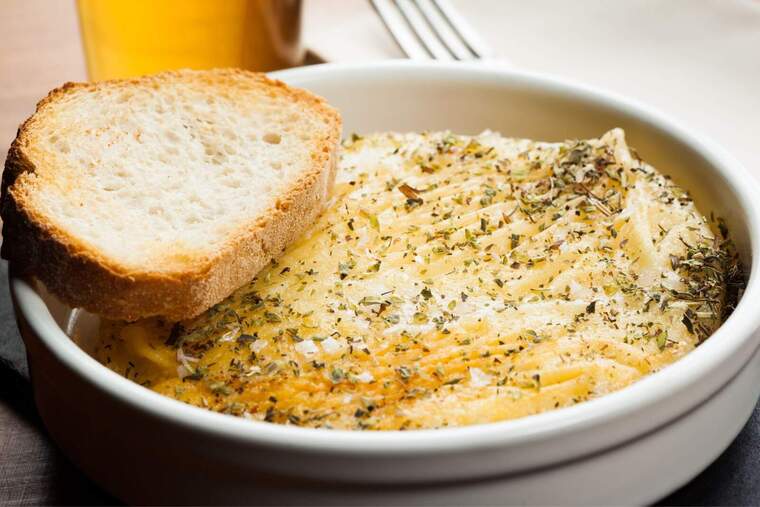 Imatge d'un bol amb formatge provolone especiat i acompanyat de pa