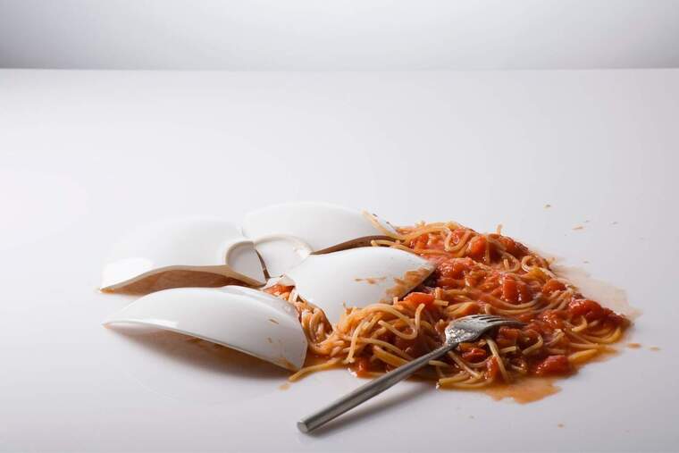 Plat d'espaguetis trencat a terra