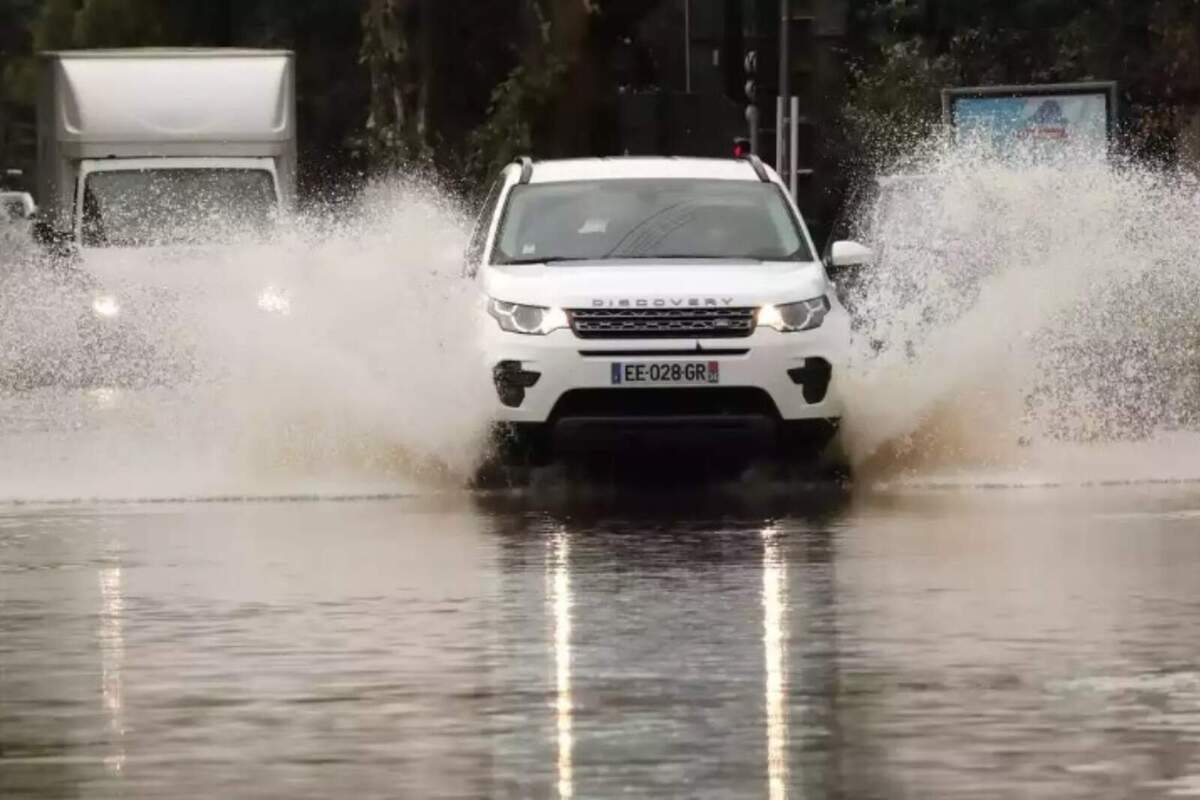 Foto d'un cotxe circulant per una inundació.
