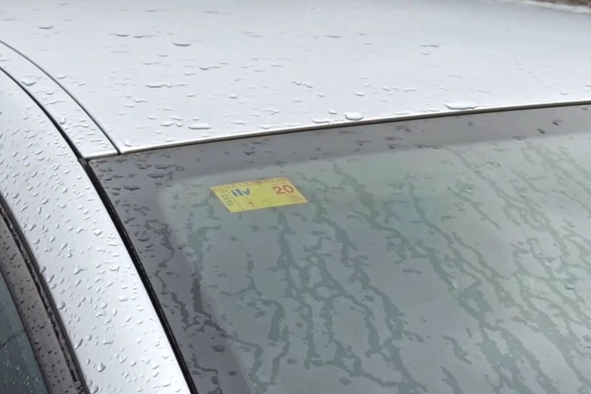 Imatge del vidre davanter d'un cotxe amb l'etiqueta de la ITV posada