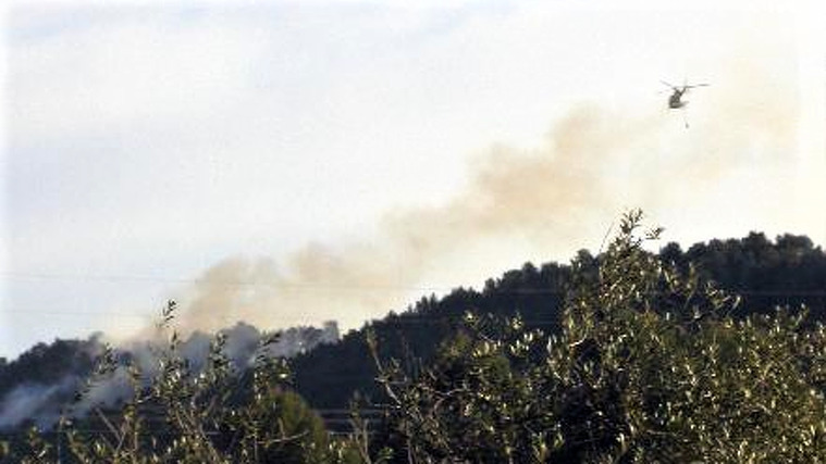 Un helicòpter bombarder sobrevolant l'incendi declarat en una parcel·la de les Borges del Camp, l'abril del 2005