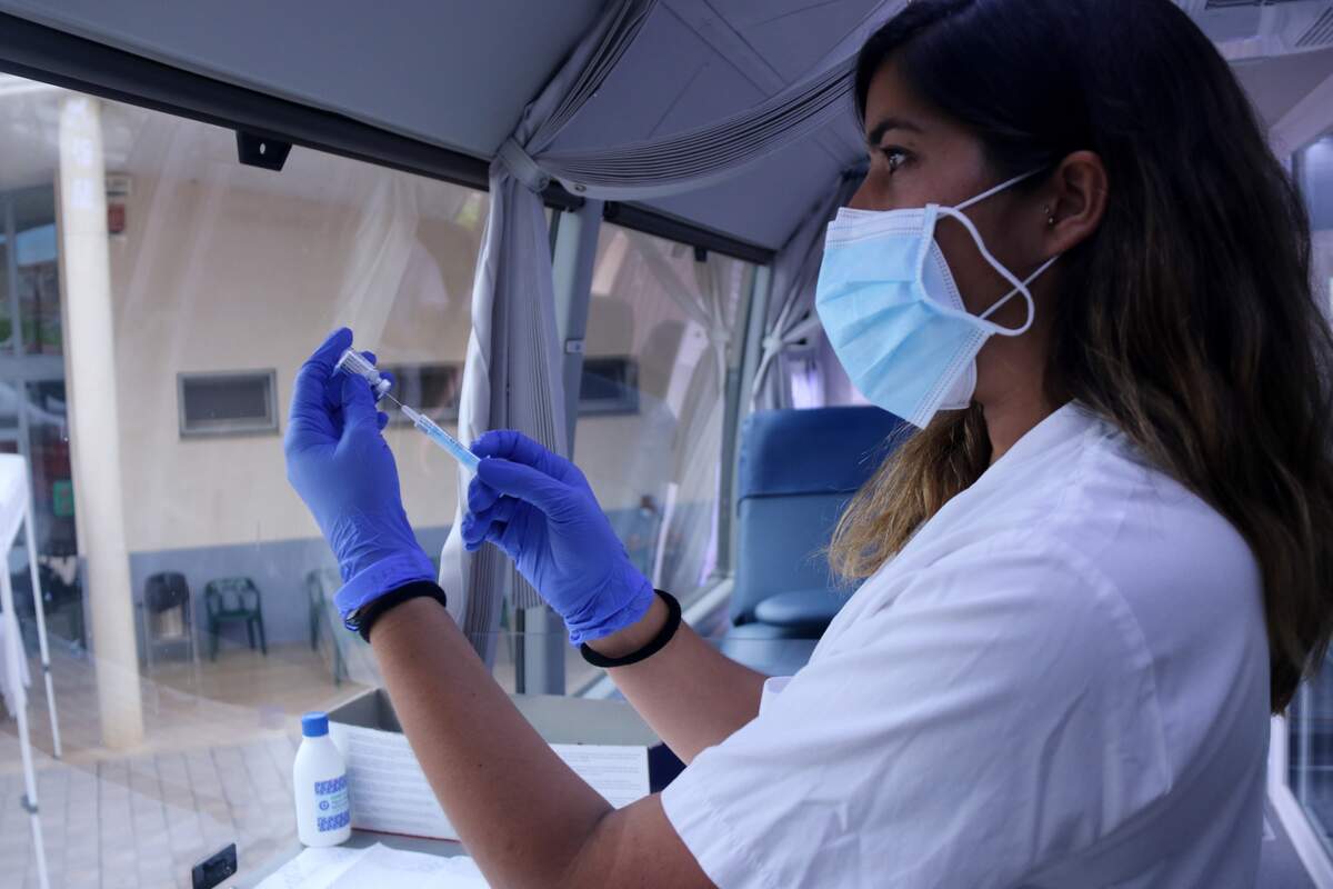 Pla mitjà d'una infermera preparant una dosi de la vacuna Janssen a l'interior del bus del Banc de Sang a Alcanar