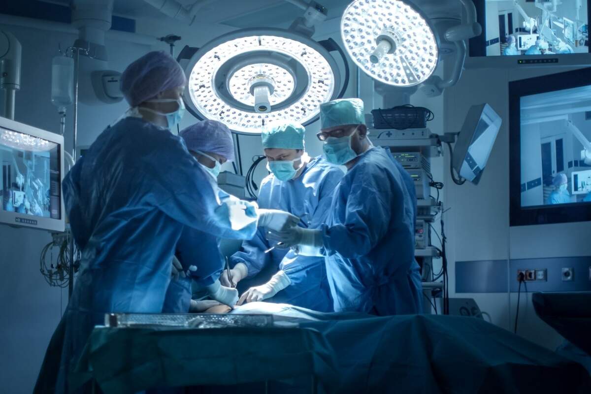 Cuatro sanitarios realizando una operación en un quirófano