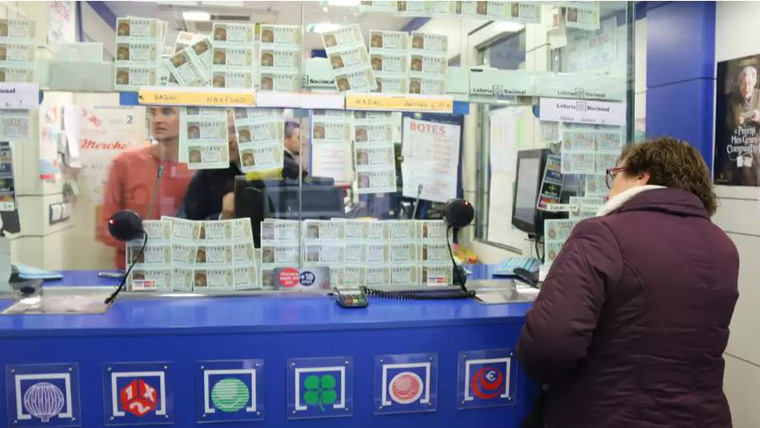 Imagen de una mujer comprando Lotería en una administración
