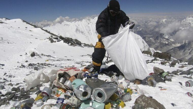 Un alpinista recoge basura en el camino a la cima del Everest