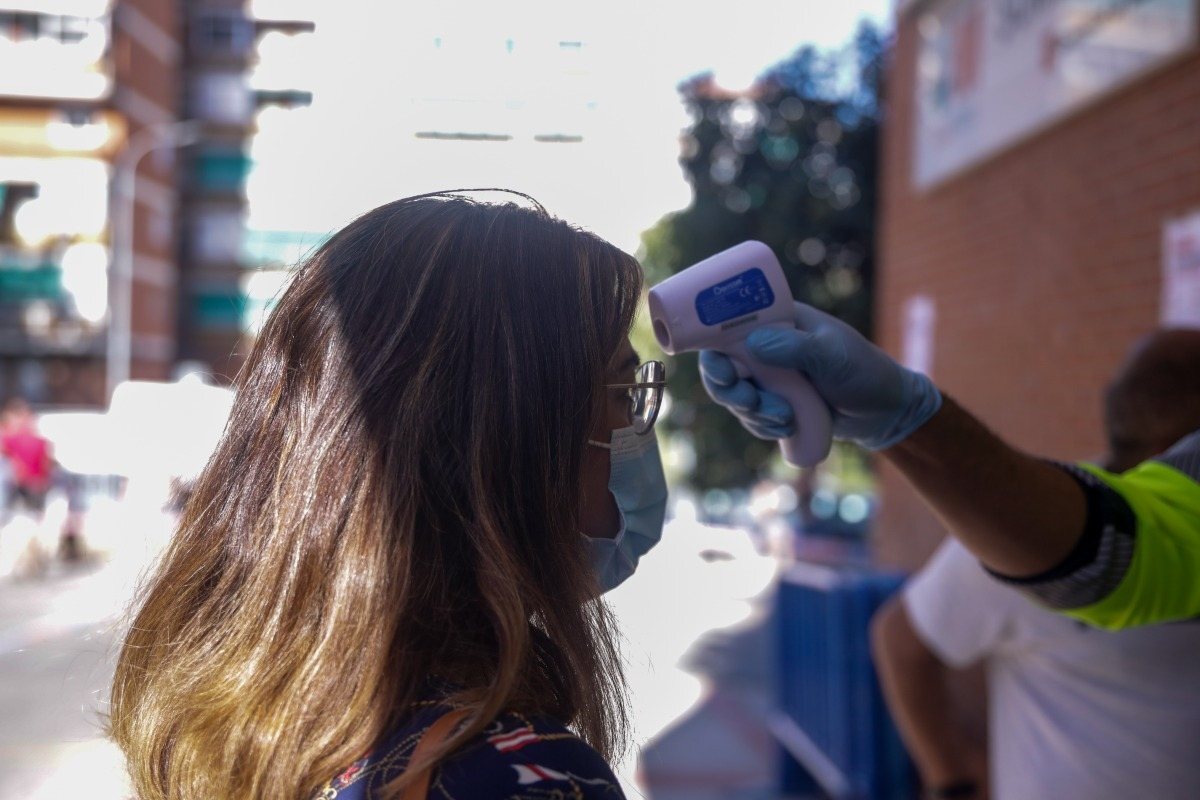Una persona toma la temperatura de una mujer con un termómetro digital