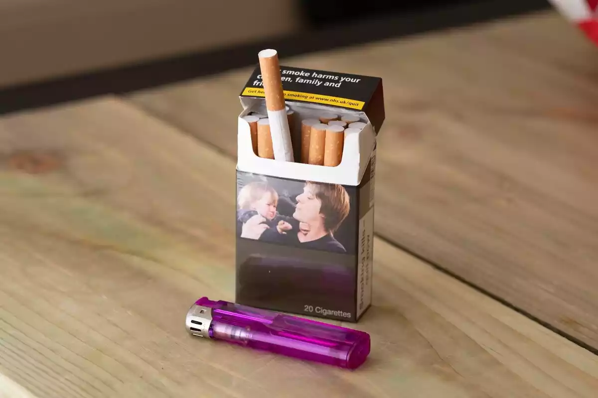 Paquete de tabaco abierto junto a un mechero Paquete de tabaco abierto junto a un mechero