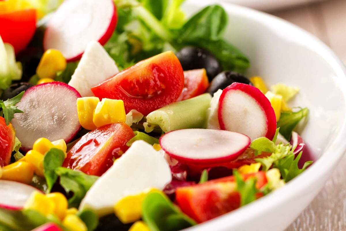 Primer plano de una ensalada variada con tomate, lechuga, maíz