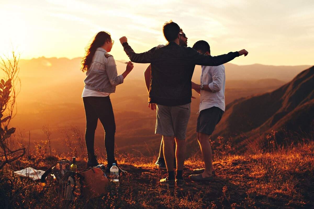Grupo de 4 personas en un paisaje de montaña al atardecer Grupo de 4 personas en un paisaje de montaña al atardecer