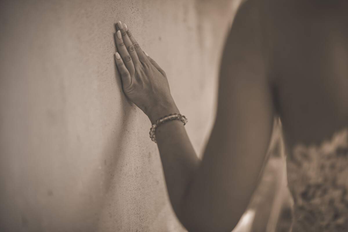 Mujer pasando la mano por una pared