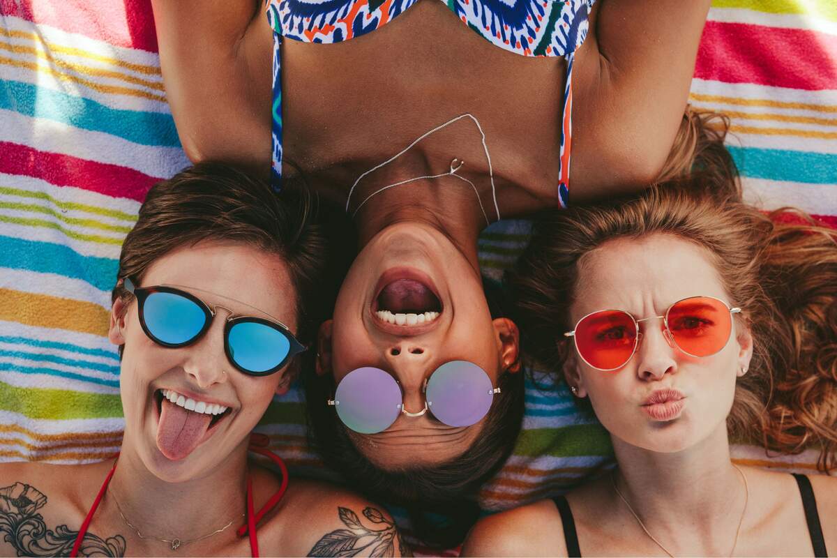 Tres chicas con gafas solares en la playa