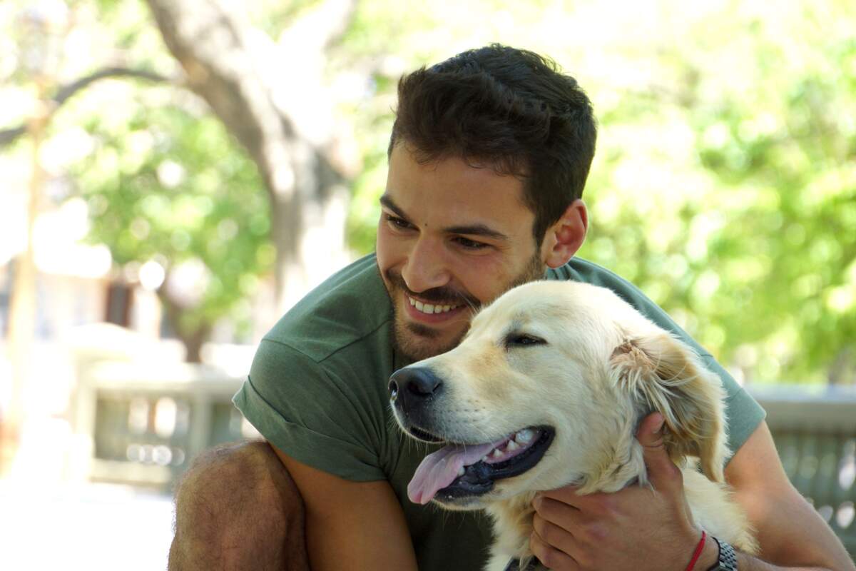 Un chico junto a un perro abrazado