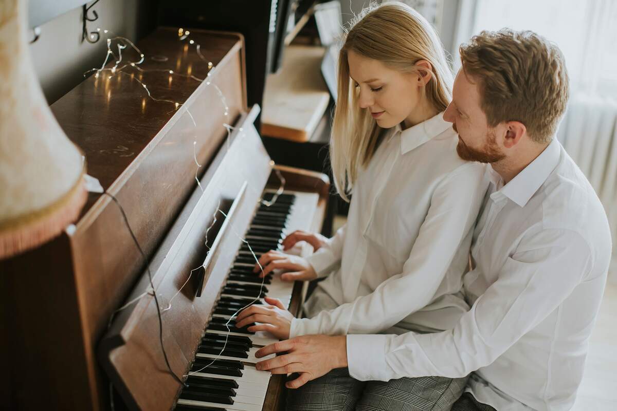Una pareja joven tocando el piano