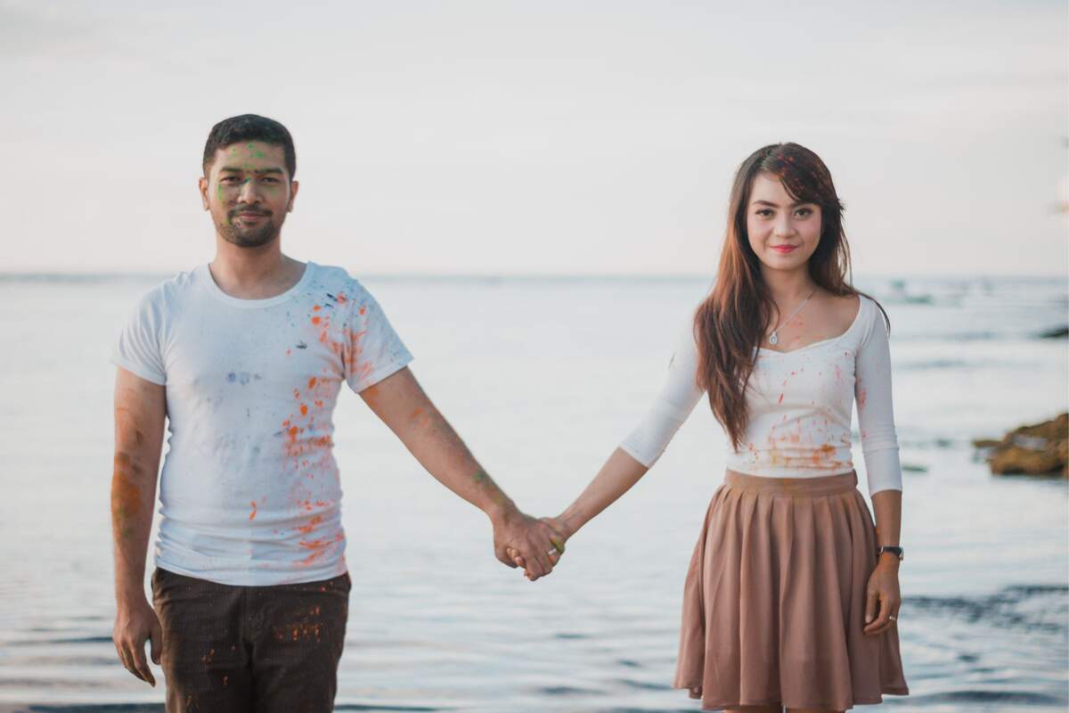 Un hombre y una mujer cogidos de la mano en el mar