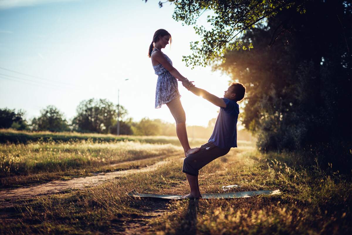 Una pareja haciendo una postura simulando una balanza en la relación