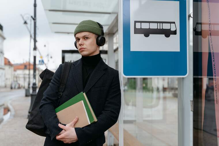 Un chico esperando en la parada de autobuses