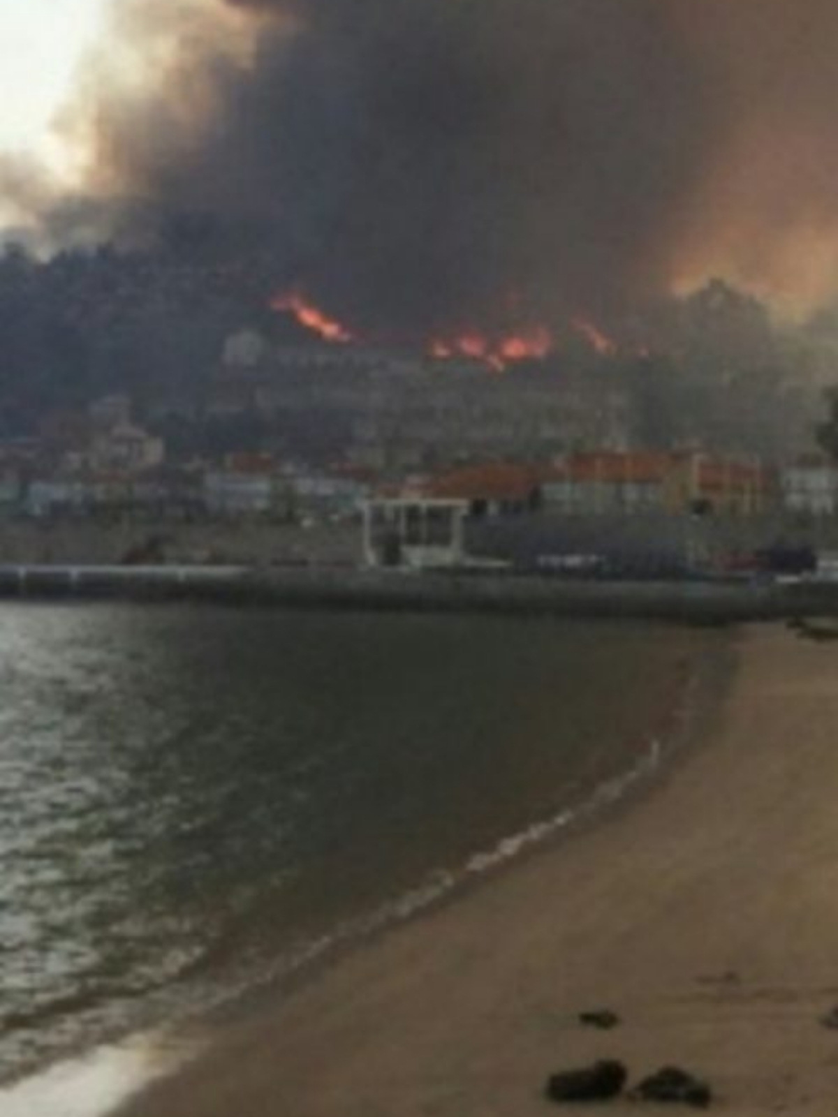Imagen de los incendios de Galicia en octubre de 2017, vistos desde una playa