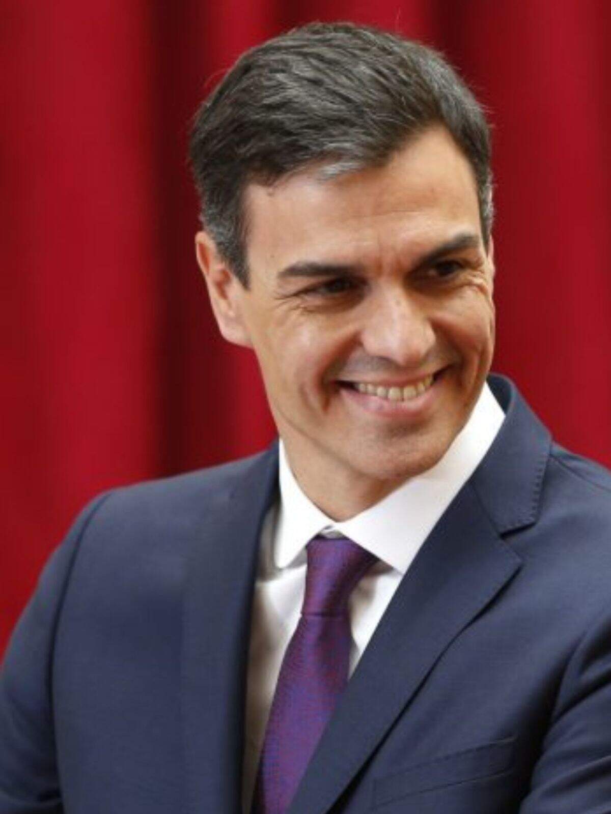Pedro Sánchez mirando de lado con una sonrisa en la cara y traje Pedro Sánchez mirando de lado con una sonrisa en la cara y traje